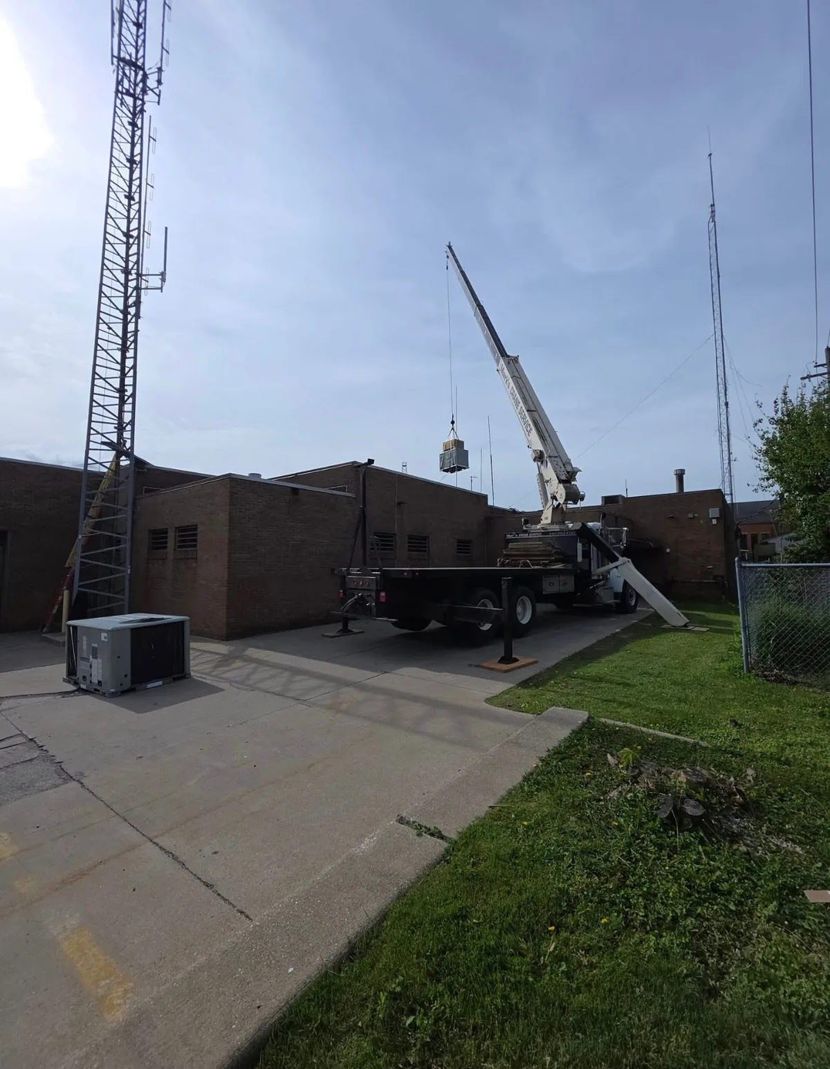 Crane lifting HVAC equipment at a commercial installation