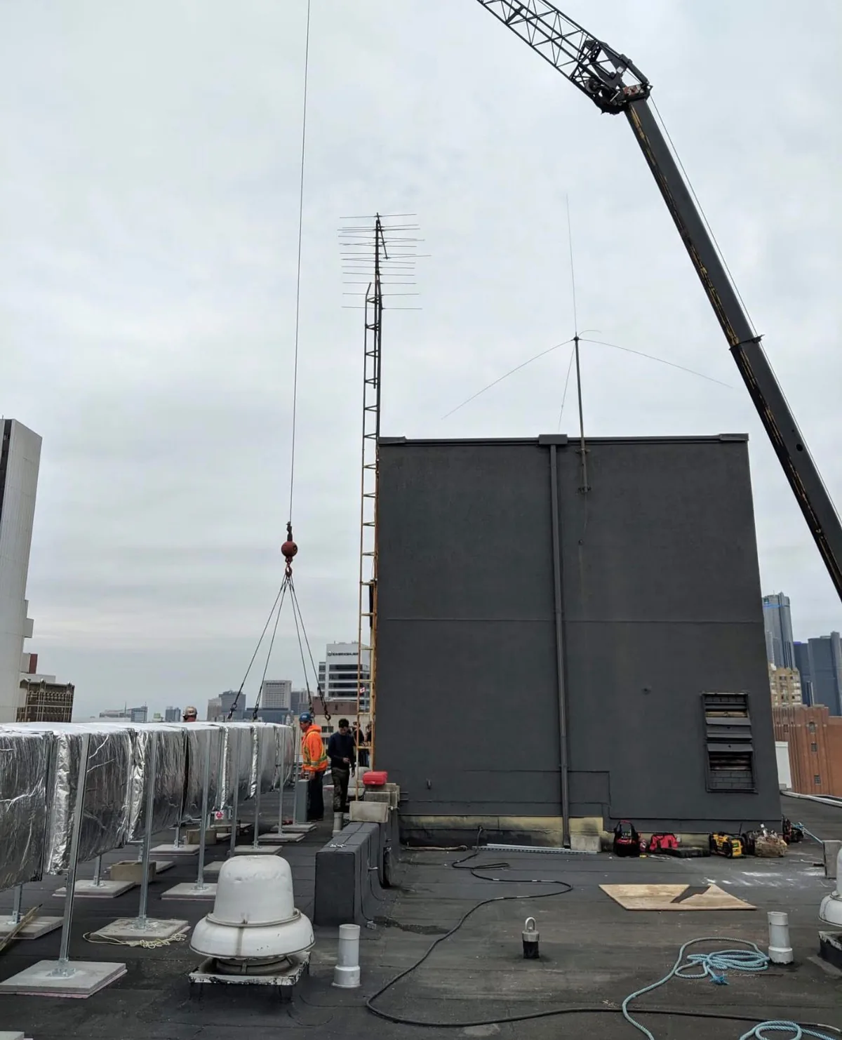 Commercial rooftop HVAC unit being positioned by crane